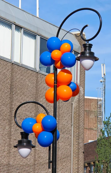 Bunte Luftballons schmücken die Säule mit Laterne an einem Stadtbaum — Stockfoto