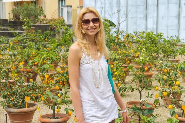Meisje in de buurt van de potplanten in kwekerij citrus — Stockfoto