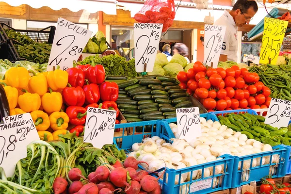 Verkoper in de buurt van een teller met groenten op een markt in Venetië, ita — Stockfoto