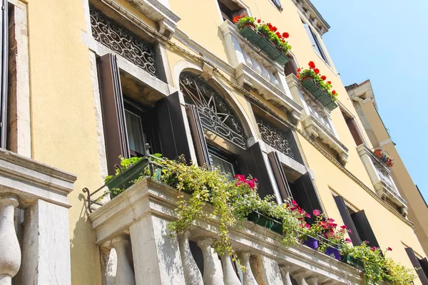 Schilderachtige Italiaanse huis met bloemen op de balkons — Stockfoto