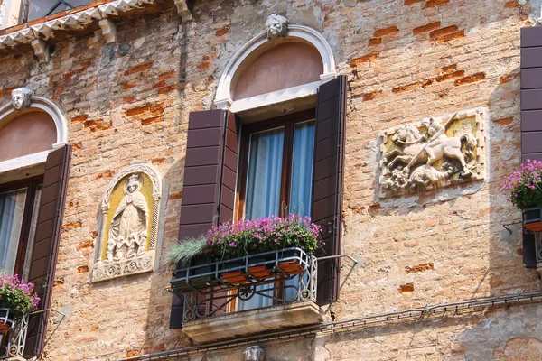 Pintoresca casa italiana con flores en los balcones — Foto de Stock