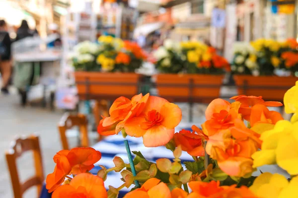 Bloemen versieren het openlucht café op de markt in Venetië, Italië — Stockfoto