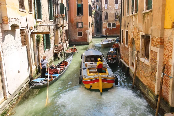 Människor i båtar rör sig längs en kanal i Venedig, Italien — Stockfoto