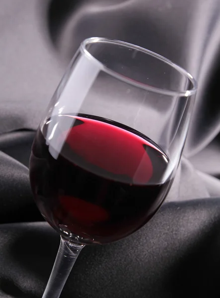 Bicchiere da vino rosso su seta — Foto Stock