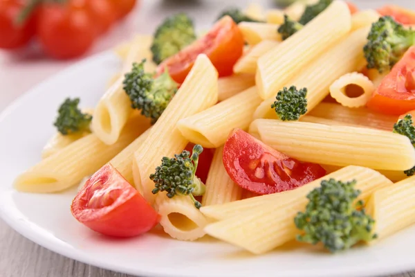 plate of pasta with tomato and broccoli