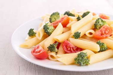 plate of pasta with tomato and broccoli