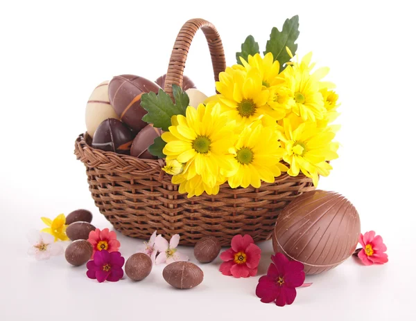 Великодні яйця в плетеному кошику з квітами — стокове фото