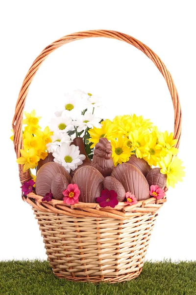 Easter eggs in wicker basket with flowers — Stock Photo, Image