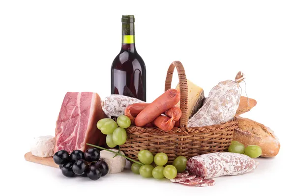 Wicker basket with sausages, ham and wine — Stock Photo, Image