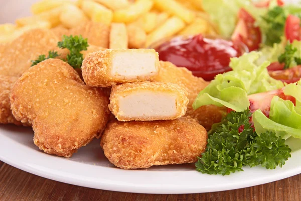 Pepitas de frango, batatas fritas e salada — Fotografia de Stock