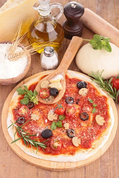 Pizza dough with tomato sauce and ingredients — Stock Photo, Image