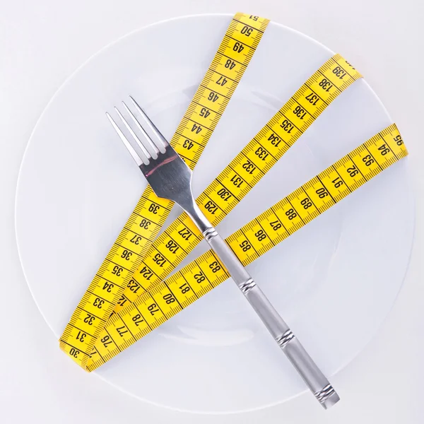 Измерительная лента на тарелке — стоковое фото