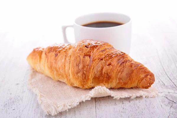 Croissant und Kaffeetasse — Stockfoto