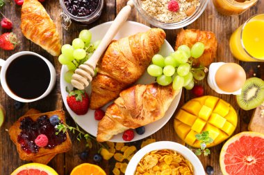 Kahvaltı masası - kruvasan, taze meyve, kahve fincanı