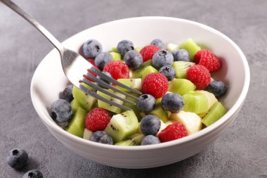 Meyve salatası ve çatal.