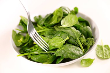 Bir kase taze ıspanak ve çatal.