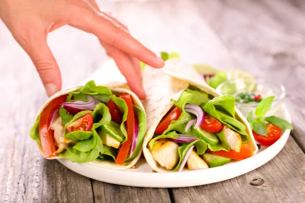 Tavuk, sebze ve kadın eli ile fajita.