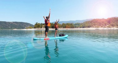 Baba ve oğul nehirde ya da gölde kürek çekerek ayağa kalkar.