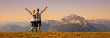 Yürüyüş yapan çift Alp Dağları 'nın panoramik manzarasının keyfini çıkarıyor