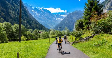 İsviçre 'de Lauterbrunnen Vadisi' nde bisiklet süren bir aile.