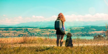 woman and dog looking at beautiful panoramic view