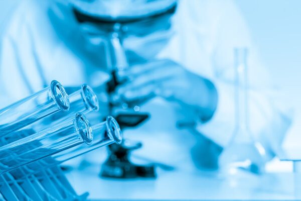 Laboratory assistant working with a microscope in lab