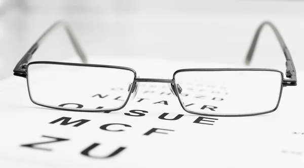 Gafas graduadas en la carta del ojo — Foto de Stock