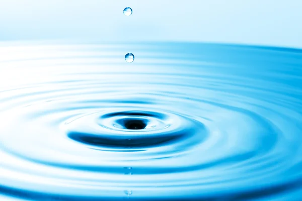 Gotita cayendo en agua azul — Foto de Stock