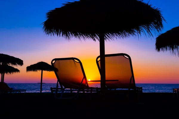 Beach umbrella on the beach at sunset — Stock Photo, Image
