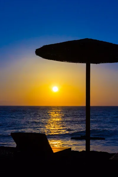 Parapluie sur la plage au coucher du soleil — Photo