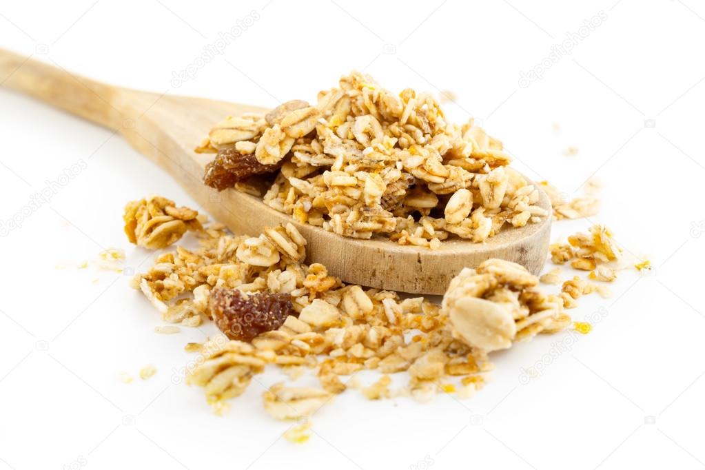 Muesli with dried fruits in wooden scoop isolated on white