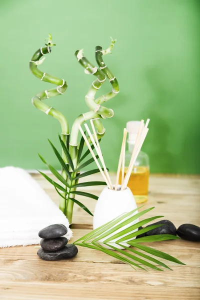 Zen-Basaltsteine und Wellnessöl auf dem Holztisch — Stockfoto
