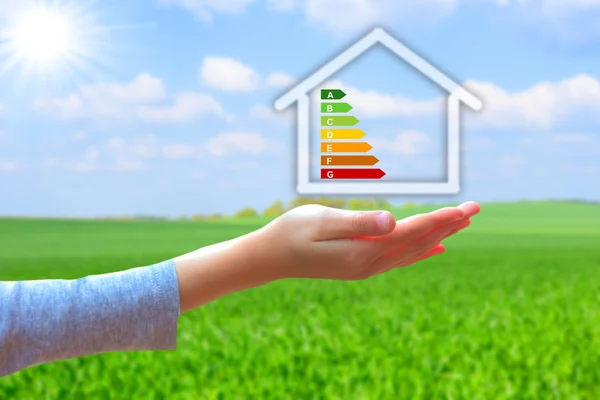 Handen met huis met energieproductiviteitsscijfer — Stockfoto