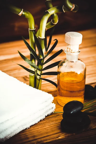 Piedras de basalto zen y aceite de spa en la madera — Foto de Stock