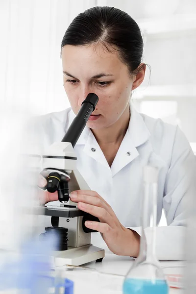 Wetenschapper met behulp van een microscoop in een laboratorium — Stockfoto