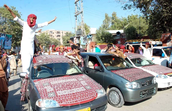 Residents of Hyderabad wearing Sindh traditional dresses dancing to celebrating Sindhi Cultural Day while on drive — Stock Photo, Image