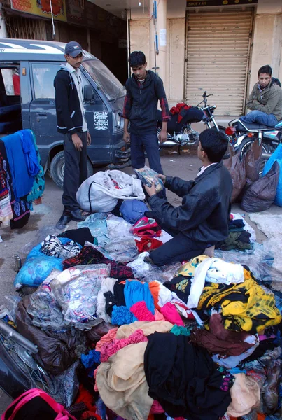 Kauppiaat pakkaavat vaatteita, jotka pelastuivat tulipalon jälkeen matkustamon sähköoikosulun vuoksi. — kuvapankkivalokuva
