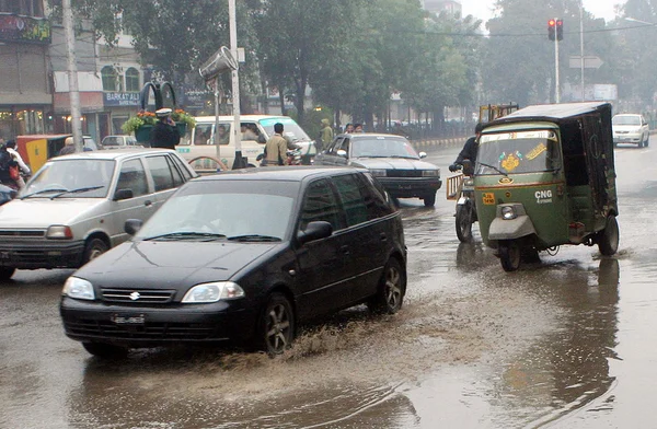 Commuters pass through Mall road during downpour of winter season — Stock Photo, Image