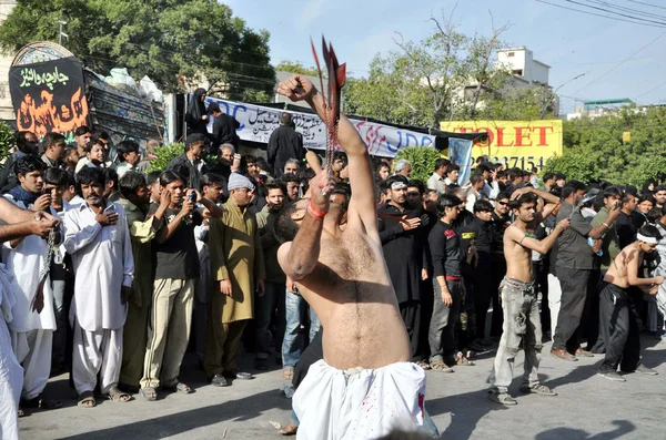 Shiite Muslims mourners scourging their bodies with knives swung in chain to show their devotion to Hazrat Imam Hussain (A.S) — Stock Photo, Image