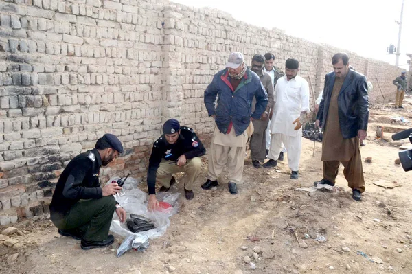 Police officials check seized weapons that recovered during a raid on delimitation of arrested accused, at Quetta bypass — Stock Photo, Image