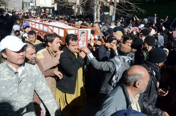 Musulmanes chiítas junto con cadáveres que murieron en la explosión de la bomba de Alamdar Road Imagen de archivo
