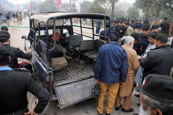 Police officials inspecting destroyed police van after a bomb blast attack near Bacha Khan Chowk — Zdjęcie stockowe