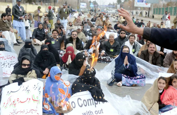 Um membro da Associação Huqooq-e-Teachers Balochistan queimar seus documentos durante manifestação de protesto para a regularização em seus empregos — Fotografia de Stock