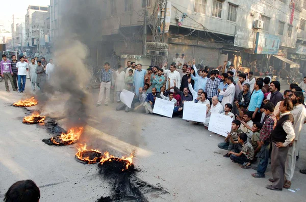 Residents of Khokhar stand near burning tyres as they are prostrating against robberies in their area — Stock Photo, Image