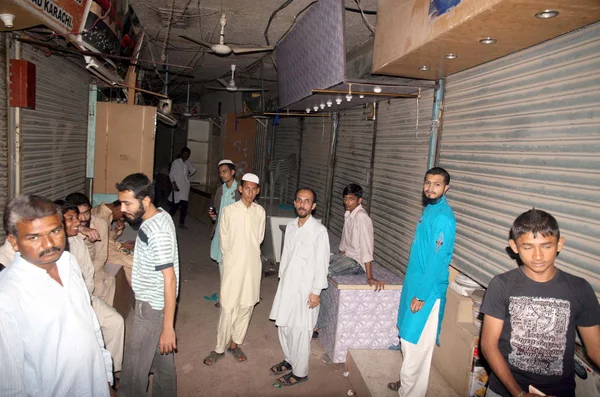 I negozianti si riuniscono nel mercato dopo la rapina in diversi negozi a Bazar-e-Faisal nella zona di Karimabad a Karachi — Foto Stock