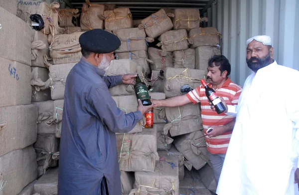 Gümrük yetkilileri anti kaçakçılık operasyonu sırasında pakistan deniz Güvenliği Ajansı tarafından kurtarılan ele geçirilen yasadışı alınan likör şişeleri göster — Stok fotoğraf