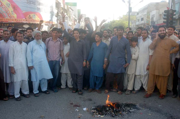 Traders burn tyres as they are protesting against killing of a shopkeeper by extortion mafia, during a demonstration at Tariq Road — Stock Photo, Image