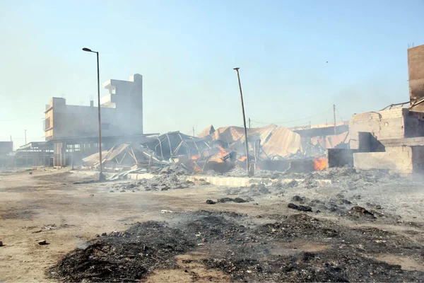 Пожарный занят тушением пожара, который вспыхнул на складе в Нью-Сабзи Манди на Главном супершоссе в Карачи — стоковое фото
