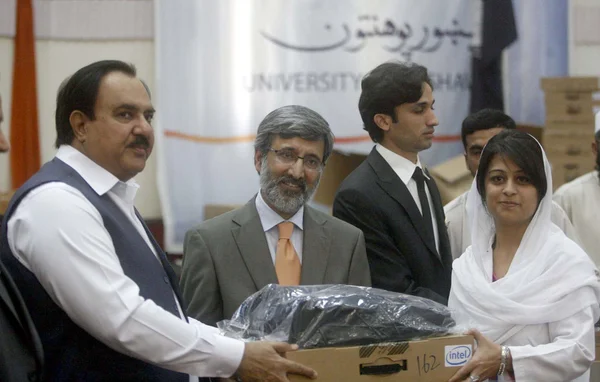El ministro federal de Salud, Zahir Ali Shah, distribuye computadoras portátiles a los estudiantes, con motivo del Día de la Convocatoria — Foto de Stock