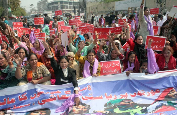 Aanhangers van vrouwelijke werknemers helpen lijnen chant slogans tegen foltering op vrouwen tijdens een protestdemonstratie ter gelegenheid van universele Vrouwendag — Stockfoto
